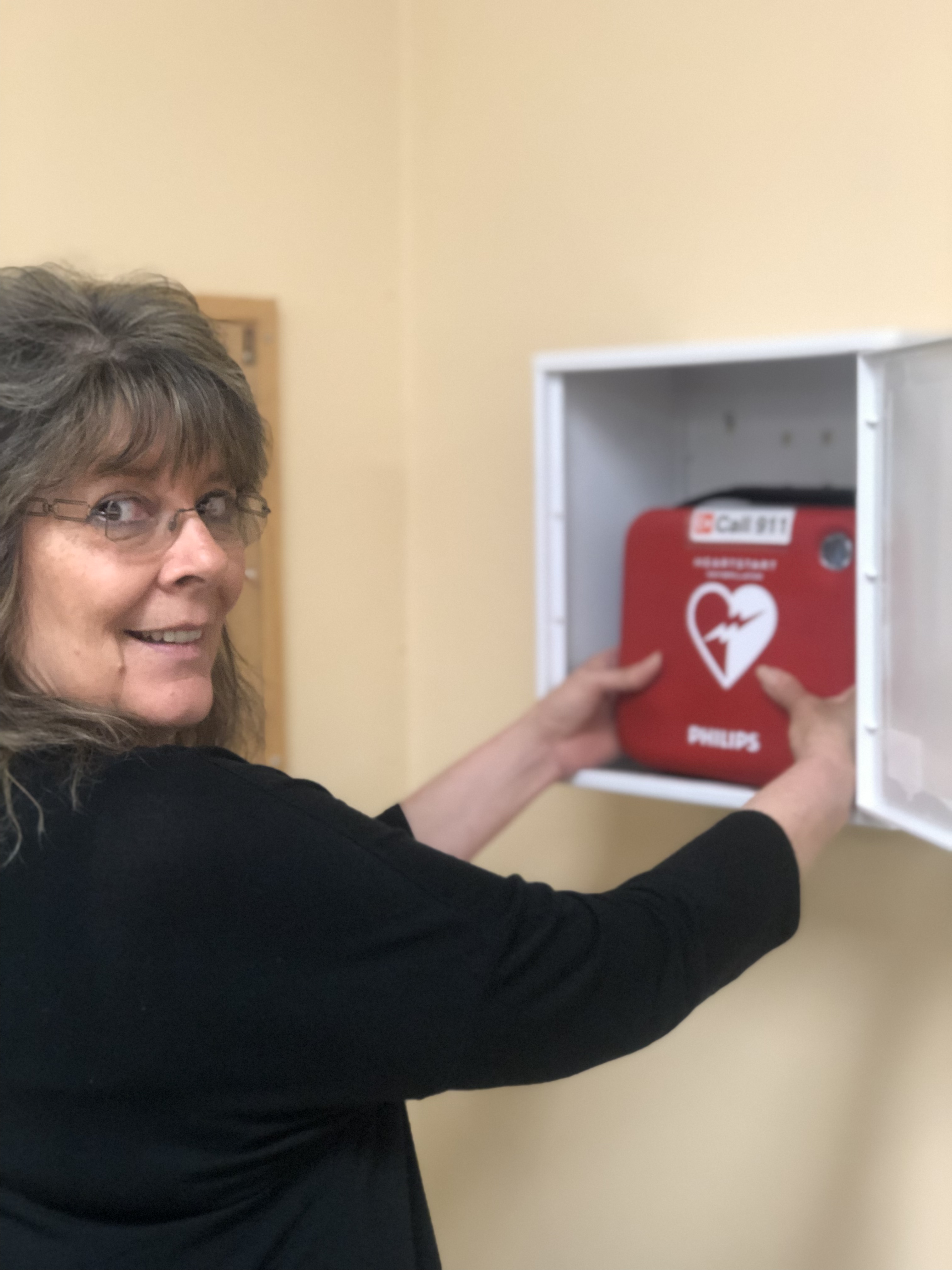 AED being mounted on wall